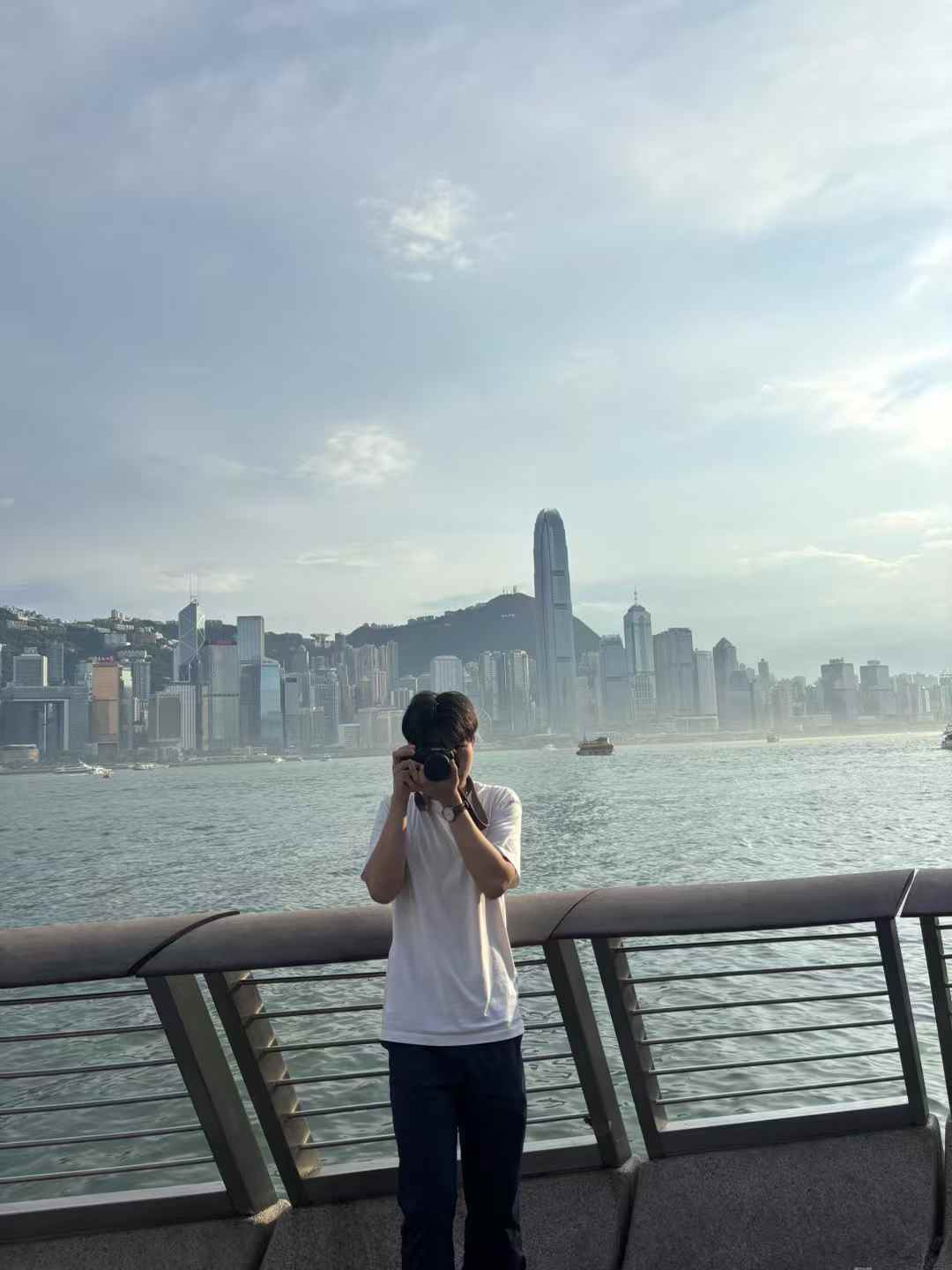 拿着相机站在城市海岸前的个人照片